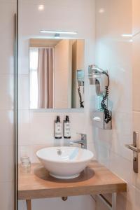 a bathroom with a white sink and a mirror at Crisol Belle Epoque in Cannes