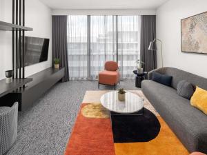 a living room with a couch and a table at The Sebel Canberra Campbell in Canberra