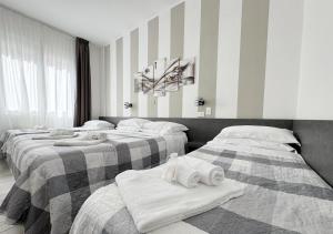 a room with three beds with towels on them at chiAma Hotel in Rimini
