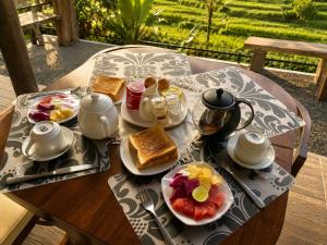 a table with a plate of breakfast food on it at The Kubu Sidemen 2 in Silebeng