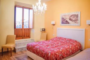 een slaapkamer met een rood bed en een kroonluchter bij Penthouse Angelo Brunetti in Rome