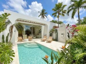 a swimming pool in the backyard of a house with palm trees at Dolce Suites in Uluwatu