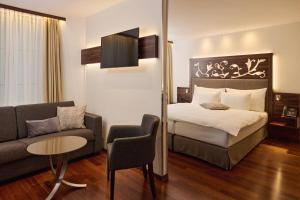 ein Hotelzimmer mit einem Bett und einer Couch in der Unterkunft Hotel Scheuble in Zürich