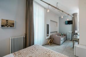 a bedroom with a bed and a couch and a window at Dimora Marinucci in Termoli