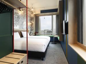 a hotel room with a bed and a tv at ibis Styles Copenhagen Orestad in Copenhagen