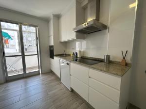 a kitchen with white cabinets and a sink and a window at Candle Home Sáenz Díez in Ourense