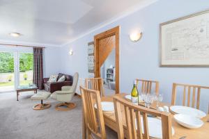 a dining room and living room with a table and chairs at Heddfan Cottage in Haverfordwest