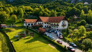 an aerial view of a house with cars parked in a parking lot at Pensiunea Sub Piatră in Sălciua de Sus
