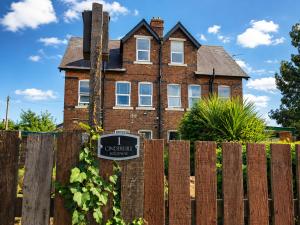 an old brick house with a sign on a fence at Cinderhouse Highbury Vale in Nottingham