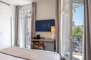 a bedroom with a bed and a desk with a window at Crisol Belle Epoque in Cannes