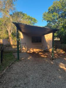 a shed with awning in front of a fence at Root&Roam Nature in Malelane