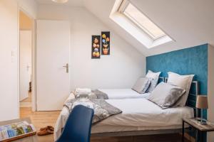 a bedroom with two beds and a blue accent wall at Villa Pré d'Oro 5 étoiles 10 personnes, spa privé, nature, Vosges Saônoises in Amage