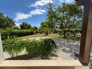 a view of a garden from a porch at La Maison du Bief in Écuisses