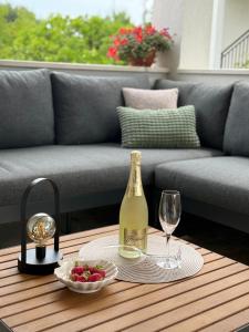 a bottle of champagne and a bowl of fruit on a table at Dalmatinac Residence in Orebić