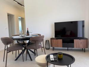 a living room with a tv and a table and chairs at Dalmatinac Residence in Orebić