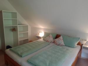 a small bedroom with a bed with green pillows at Apartment in Hofstetten surrounded by nature in Hofstetten