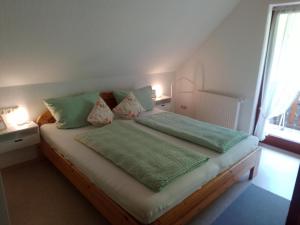 a bedroom with a bed with green pillows and a window at Apartment in Hofstetten surrounded by nature in Hofstetten