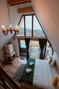 ein Schlafzimmer mit einem Bett und einem großen Fenster in der Unterkunft A-Frame Prislop,Hațeg in Silvaşu de Sus