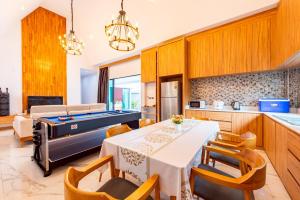 a kitchen with a dining room with a pool table at King Arthur Pool Villa in Nong Prue