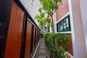 a walkway next to a building with red doors at King Arthur Pool Villa in Nong Prue