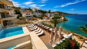 a view of a resort with a swimming pool and the ocean at Villa Bilic in Rogoznica