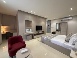 a bedroom with a large bed and a red chair at فندق فاليا in Al Kharj