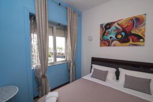 a bedroom with a bed with a painting on the wall at Maa Guest House in Civitavecchia