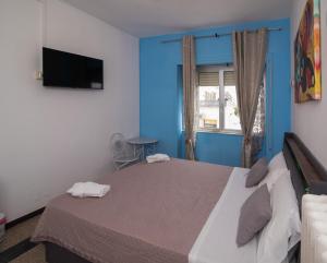 a bedroom with a large bed with a blue wall at Maa Guest House in Civitavecchia