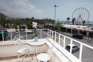 a balcony with a table and chairs and a ferris wheel at Maa Guest House in Civitavecchia