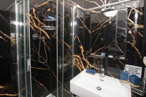 a bathroom with a sink and a glass shower at Maa Guest House in Civitavecchia