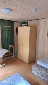 a room with a bed and a cabinet and a chair at Ferienzentrum Briesensee in Neu Zauche +2 photos