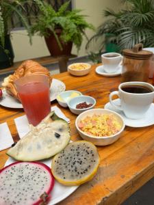 a wooden table topped with plates of food and drinks at Hostal Marín Central - Quito in Quito