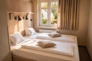 two beds in a room with a window at Pokoje Pasáž in Doksy