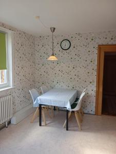 a dining room with a table and a clock on the wall at Zwischen Acker und Herz Hartmannshof in Algermissen