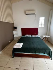 a bedroom with a large bed with a green blanket at Raíces Vivas Dúplex - Cochera Privada en Oberá in Oberá