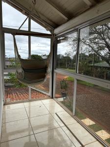 a hammock hanging in a room with windows at Raíces Vivas Dúplex - Cochera Privada en Oberá in Oberá