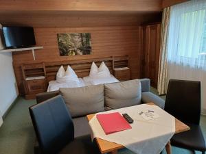 a hotel room with a couch and a bed and a table at Haus zur Linde in Wagrain