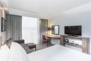 a hotel room with a living room with a television at Hampton By Hilton Blackpool in Blackpool