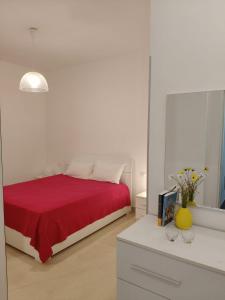 a bedroom with a bed with a red blanket at b&b la Conocchia in Curti