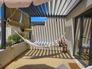 a hammock on the balcony of a house at Viladraga - Casa da Adraga in Colares