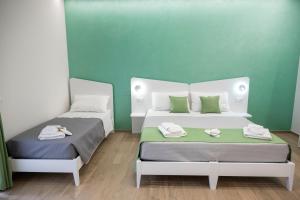 two beds in a room with green walls at B&B Melavì in Lizzano +24 photos