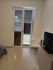 a living room with a flat screen tv and a window at b&b la Conocchia in Curti