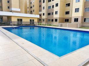 a large swimming pool in front of a building at Hosts BR - Apartamentos funcionais in Fortaleza
