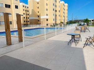 a patio with a table and chairs next to a pool at Hosts BR - Apartamentos funcionais in Fortaleza