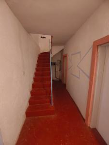a staircase in a room with red carpeting and a stair case at Old Town Casa in Ulcinj