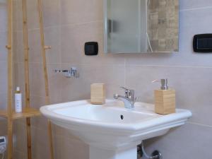 a bathroom with a white sink and a mirror at Chicche di Lavanda in Valmadonna