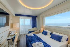 a hotel room with a bed and a large window at Hotel Tiffany's in Riccione +106 photos