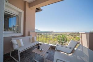 a balcony with a bench and a table and chairs at Gerania nature Residence 22 in Siátista
