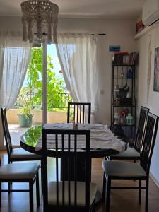a dining room with a table and chairs and a window at Babić Rituals apartments in Makarska