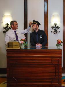 a man adjusting another mans hat in front of a podium at Hôtel Juana in Juan-les-Pins +92 photos